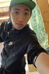 a young man wearing headphones and a hat